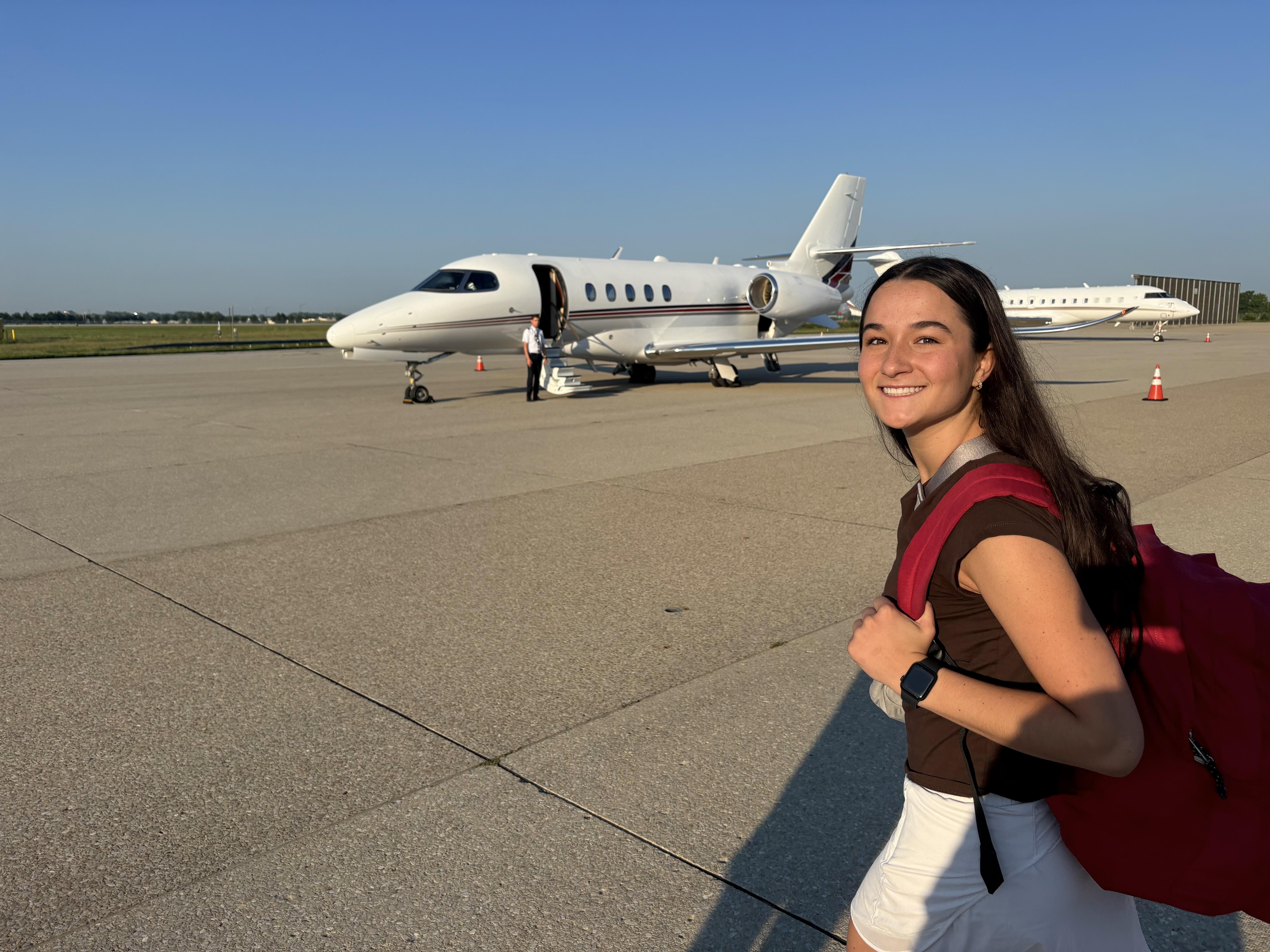 Lexy Payne with backpack walking towards NetJets plane