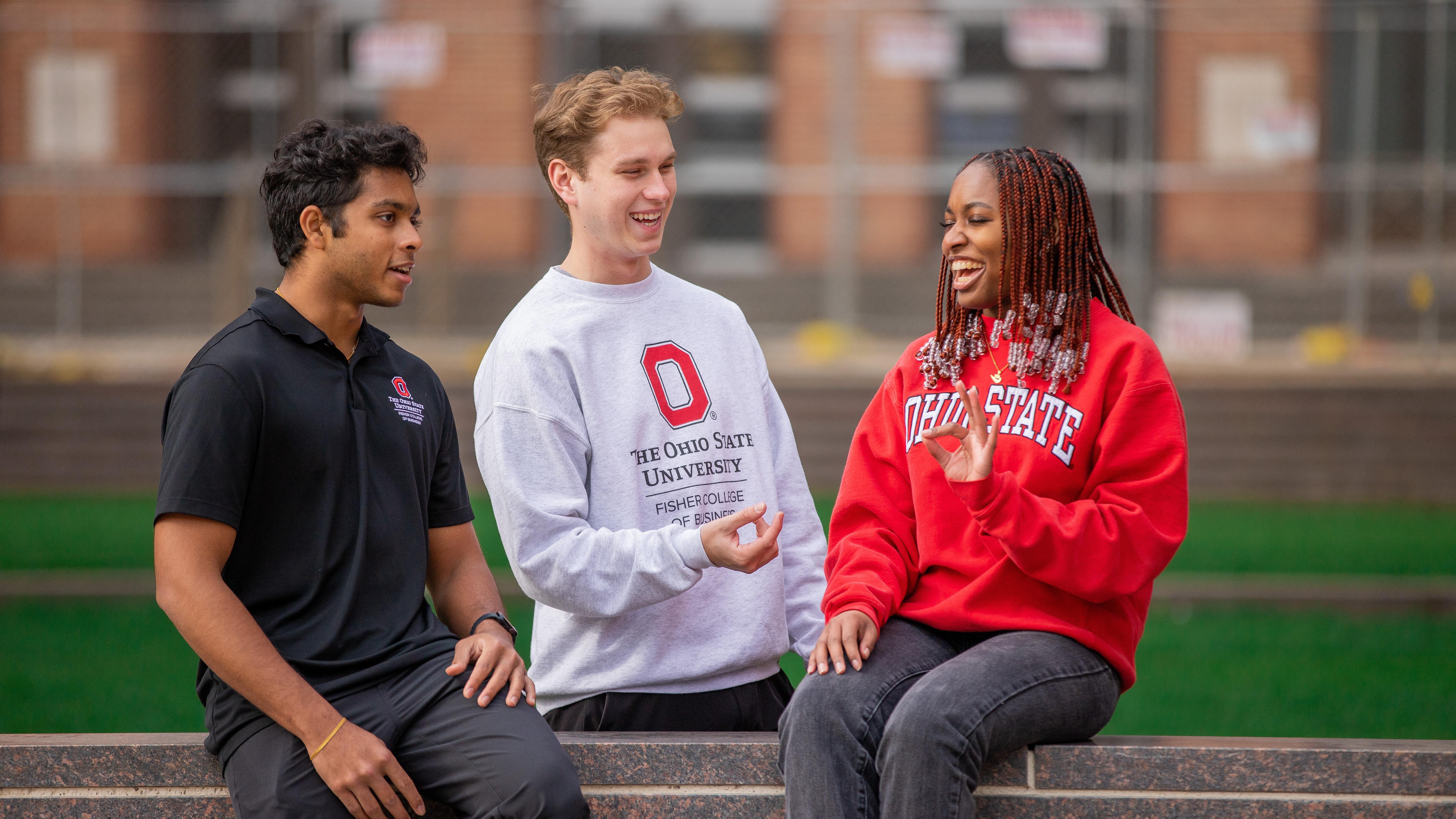 Three students conversing on campus.