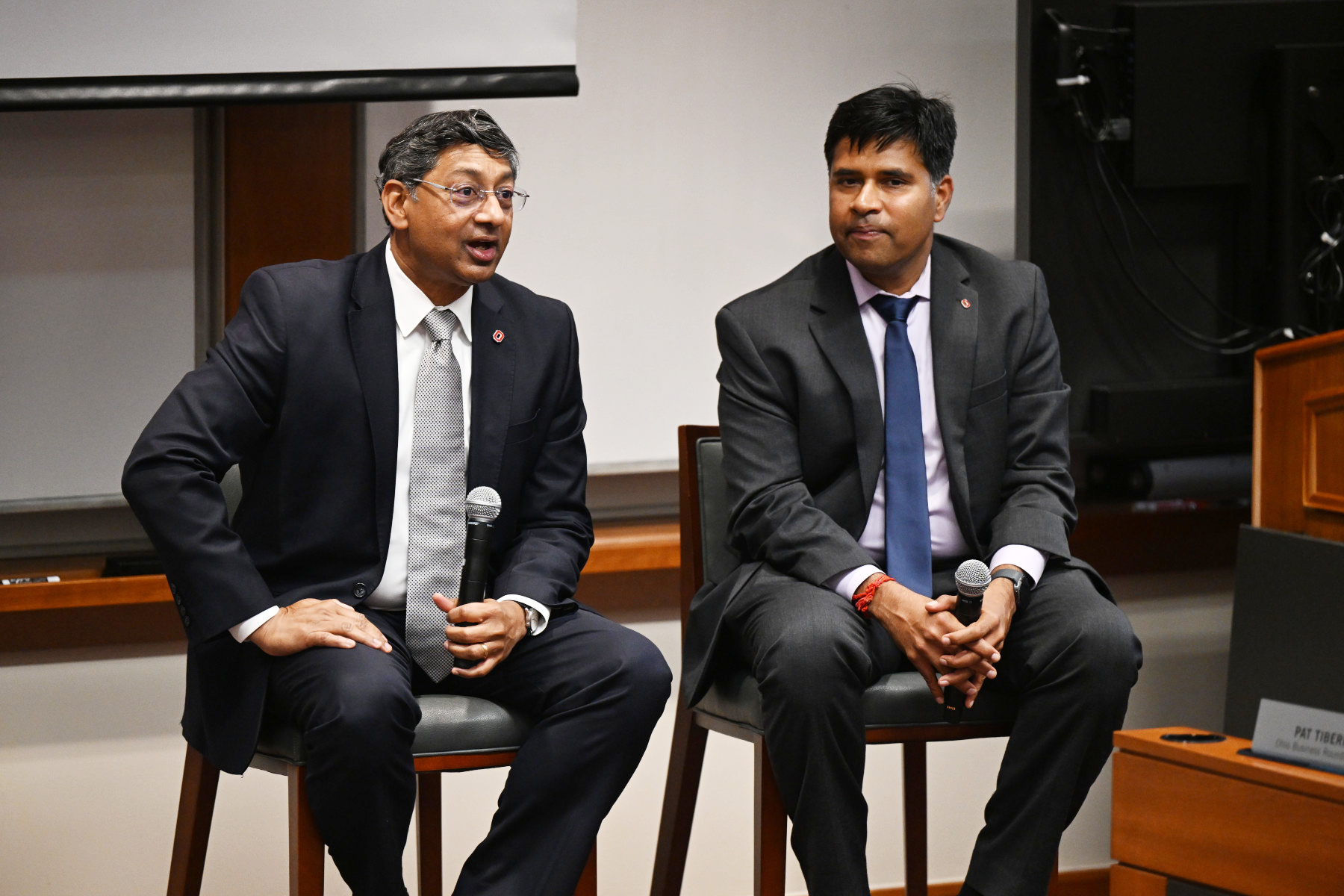 Ohio State President Ravi Bellamkonda and Fisher Interim Dean Aravind Chandrasekaran seated on stage holding microphones during a discussion with business leaders at a campus event.