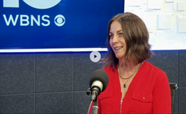 Chantel Fucci in a red shirt speaks inside a TV studio for an interview.