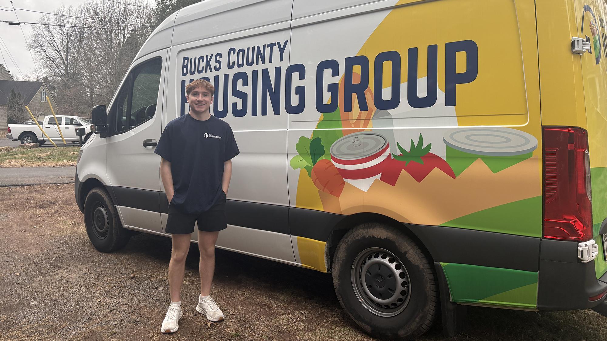 Jack Swartley poses next to a colorful delivery van.