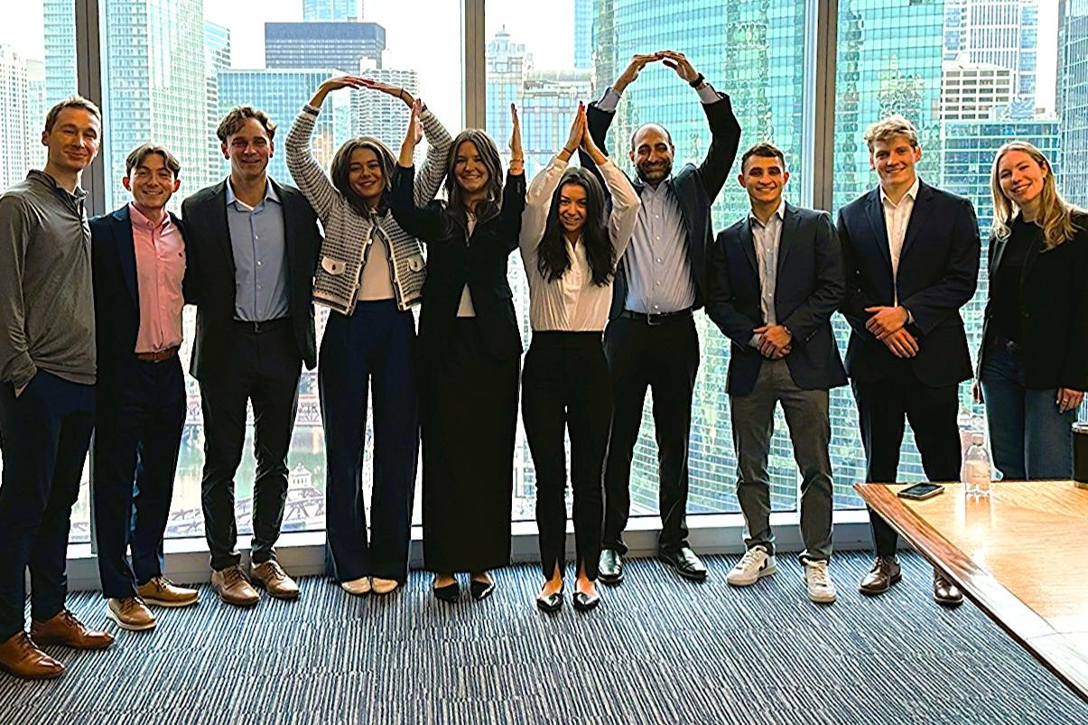 Leaders of the Fisher Real Estate Society and Alumni Board mentor Arun Singh, fourth from right, pose for a photo in a Chicago office building.