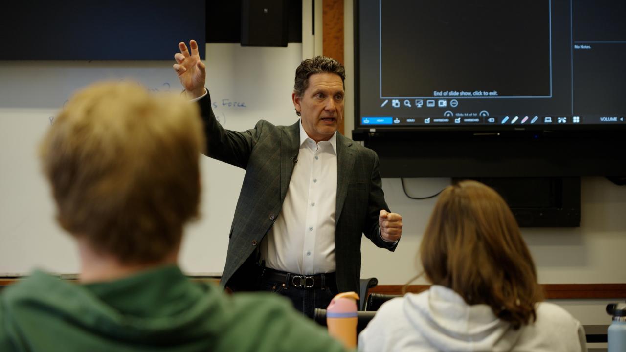 Jeff Prestel gestures while speaking to students in a classroom at Fisher.