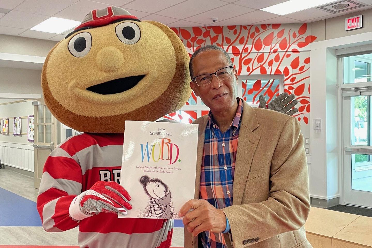Dwight and Brutus Buckeye are holding up a book titled My Special Word.