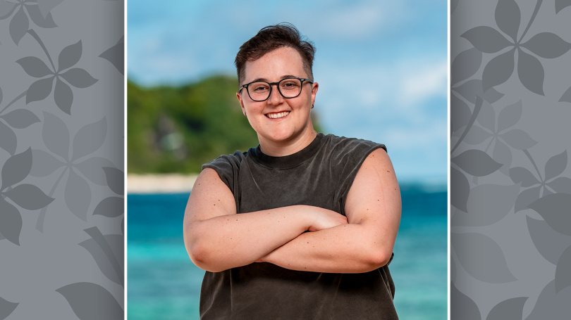 Nicole Mazullo posing with arms crossed and the ocean behind her.