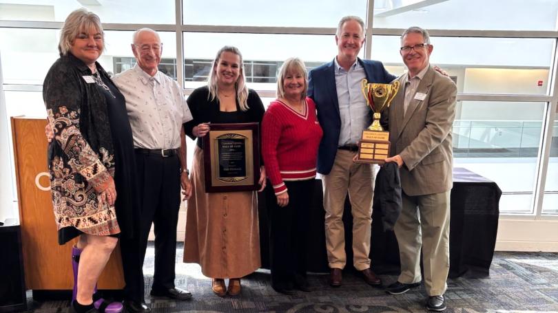 Group photo of Dick Hitchcock, friends and family holding the Columbus Logistics Hall of Fame award
