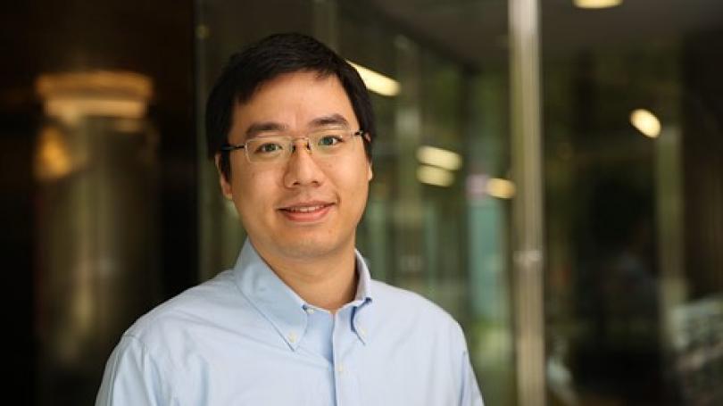 portrait of Yuheng Hu wearing glasses and dressed in light blue dress shirt 