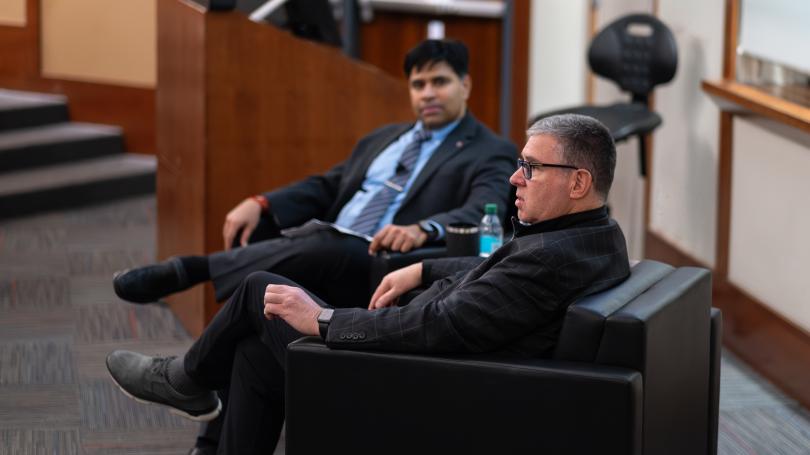 Interim Dean Aravind Chandrasekaran and James Kavanaugh sitting in chairs in front of classroom