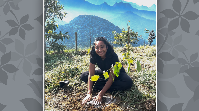 Safa Mohamed sitting on the ground planting a sappling at Sinal do Vale in Brazil.
