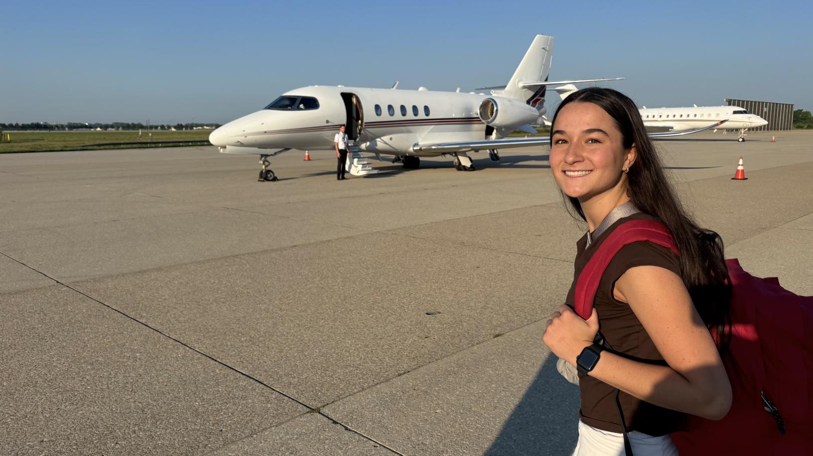 Lexy Payne on a tarmac with a plane