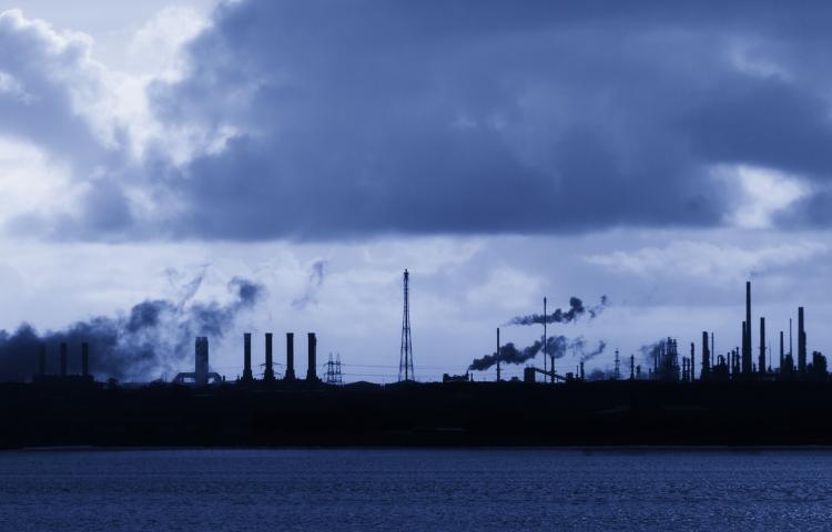 Stock image of smoggy air pollution over smoke stacks