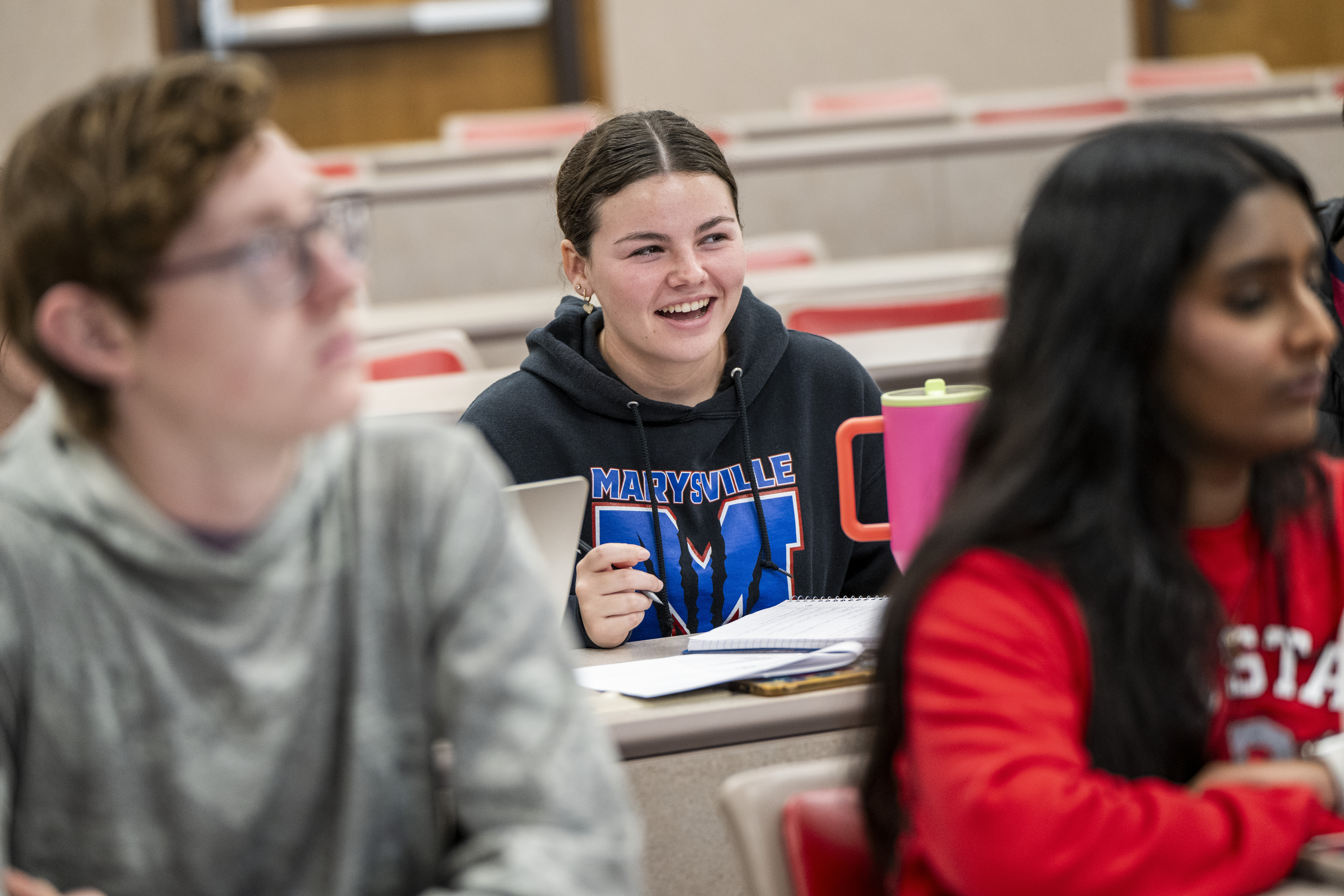 smiling prospective undergraduate student sitting in an admissions presentation
