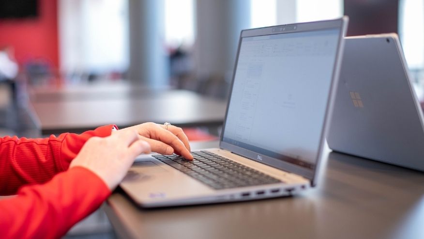 close up of hands typing on a laptop