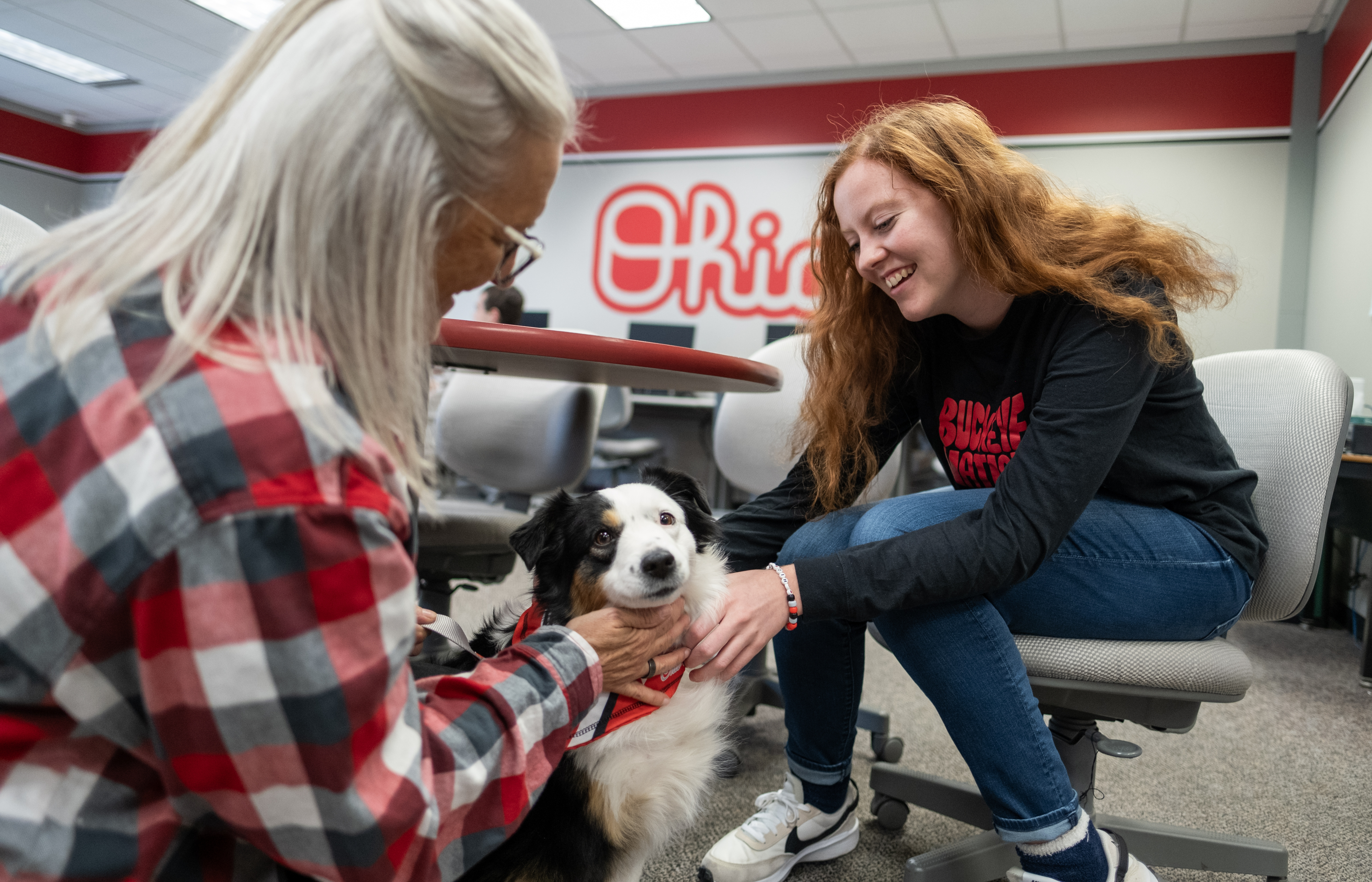 two people petting a therapy dog from Buckeye Paws