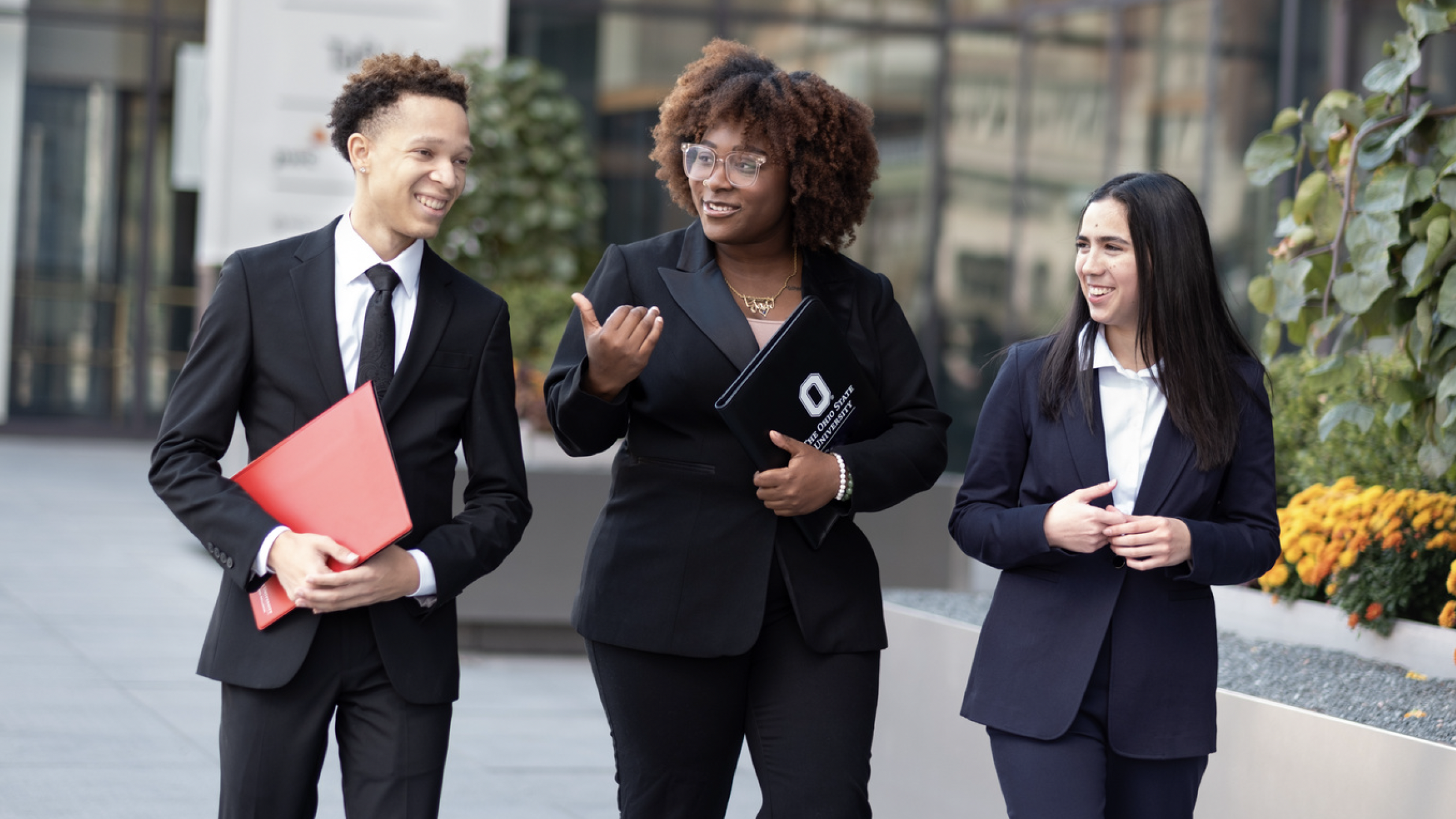 Students in professional attire walking together while conversing.