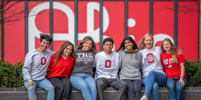Group of Fisher students pose arm in arm on campus