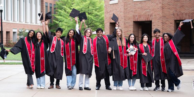 group of fisher students on fisher's campus wearing caps and gowns