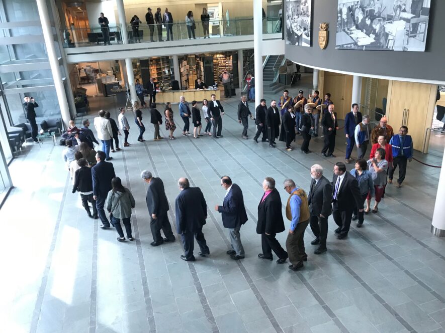 La commissaire des Territoires du Nord-Ouest, le président de la chambre, le premier ministre et son cabinet, les députés, le greffier de la chambre et tout le personnel de l’Assemblée législative ont pris part à un cercle de danse au rythme des tambours dénés à la fermeture de la 18e législature, le 23 aout dernier. Les élections seront officiellement déclenchées le 2 septembre à 10 h. — Photo : Batiste Foisy, avec l’autorisation de L’Aquilon