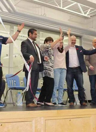 En complet veston, ruban à la main, le ministre Alfred Moses célébrait en 2018 l’inauguration du nouveau gymnase de l’école Allain St-Cyr. — Photo : Courtoisie Christine Ratel