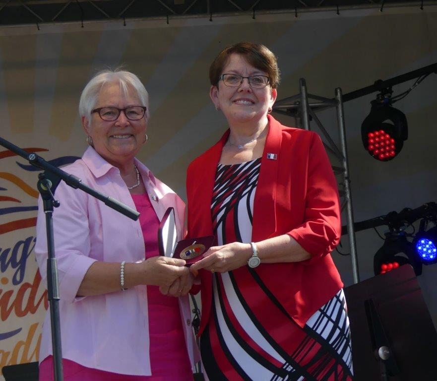 Louise Imbeault, à gauche, présente la médaille Léger-Comeau à Claudette Thériault. — Norbert LeBlanc