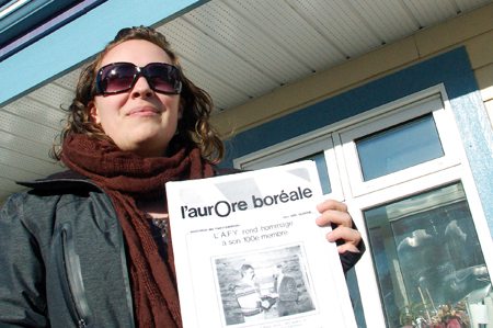 Comme l'Aurore boréale, Jasmine Forget est née au Yukon en 1983. Aujourd'hui, maman d'une petite fille de trois ans, la jeune femme a grandi avec le journal francophone. Jasmine présente ici une des premières éditions du bi-mensuel yukonnais.