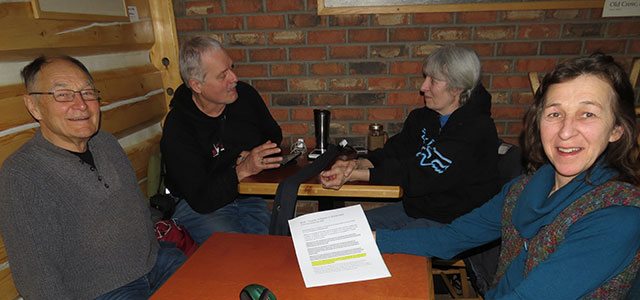 Nous avons surpris quelques membres de Frackfree Yukon Alliance en pleine discussion lors d'une réunion à la boulangerie. Nous pouvons voir Jacqueline Veilleux avec en main un exemplaire de la Charte des droits et règlements pour communautés durables. Photo : Janice Durant.