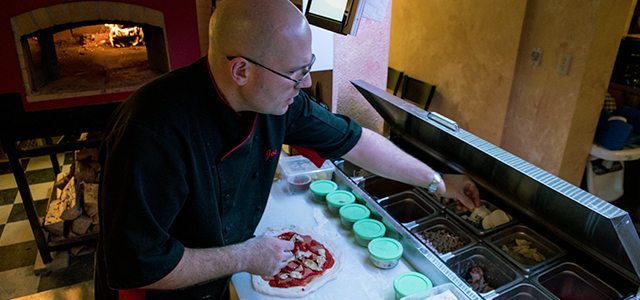 Joseph Cook prépare une pizza dans ses nouveaux locaux sur la 2e Avenue à Dawson. Photo : Hélène Roth  