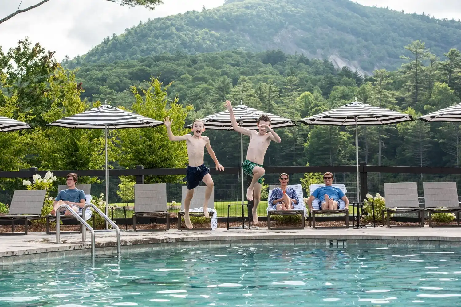 Two Young Boys Jumping Into the Pool