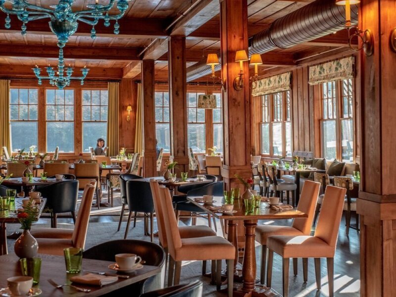 A warmly lit dining room with freshly set tables