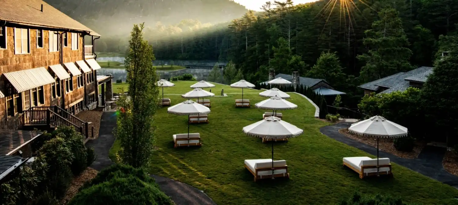 The sun rising over a lawn filled with day beds and umbrellas