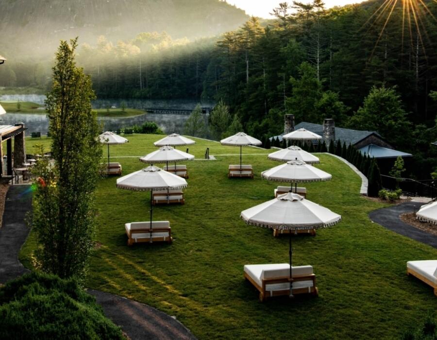 The sun rising over a lawn filled with day beds and umbrellas
