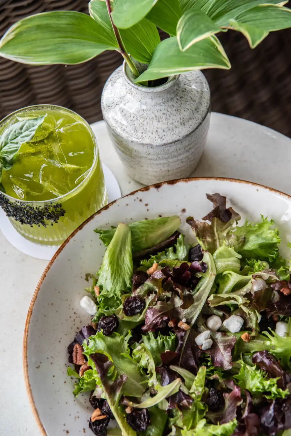 A refreshing salad set beside a cocktail