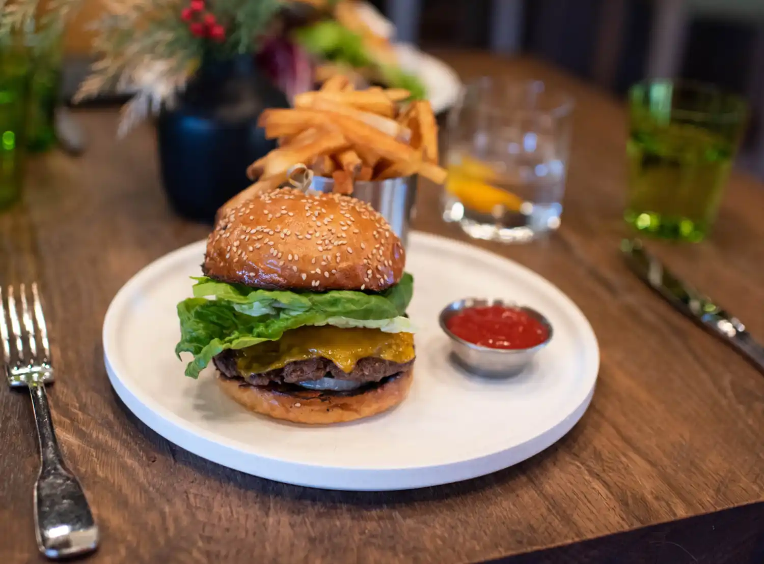 A burger and fries served with a side of ketchup