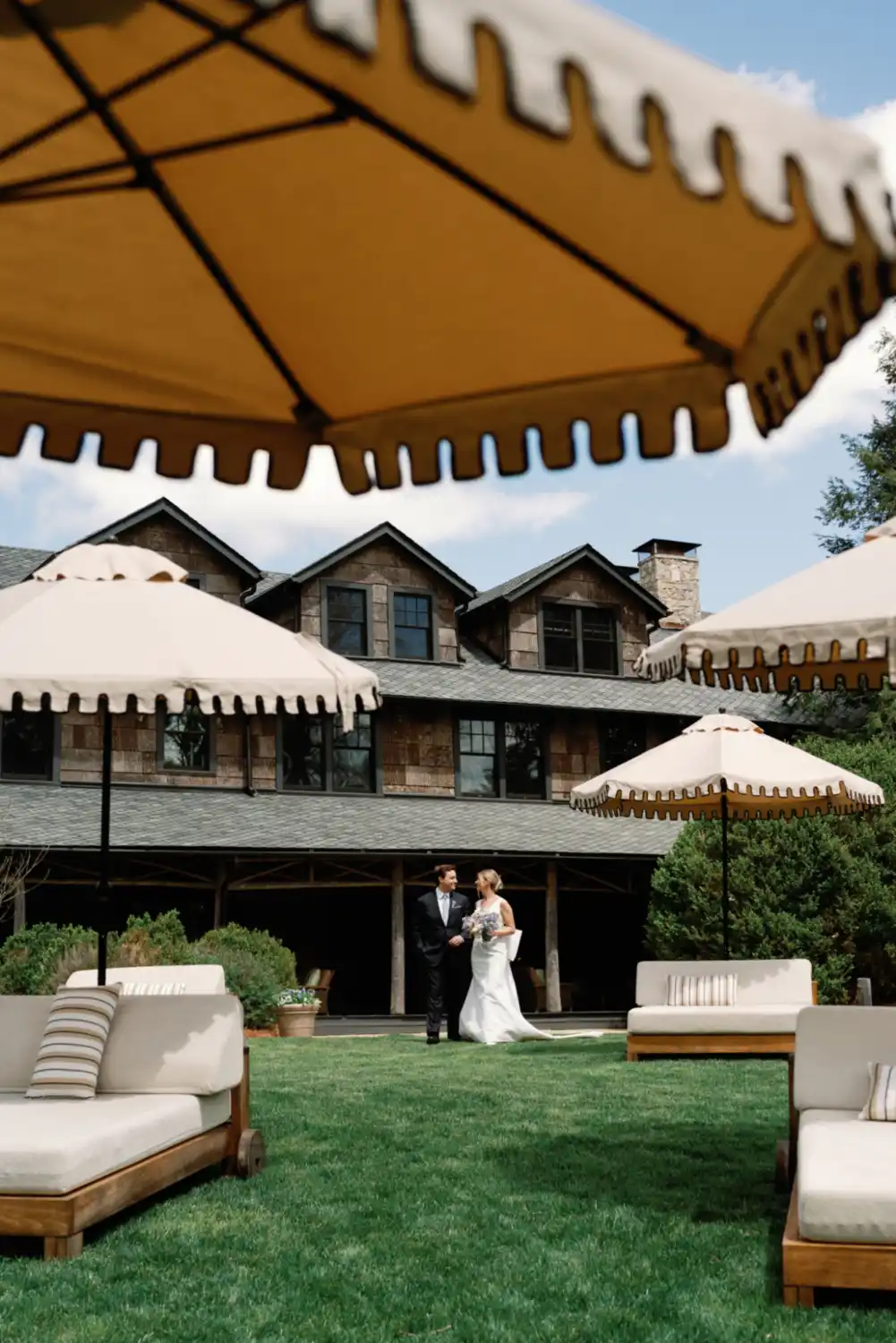 A couple smiling while walking outside of High Hampton Inn on their wedding day