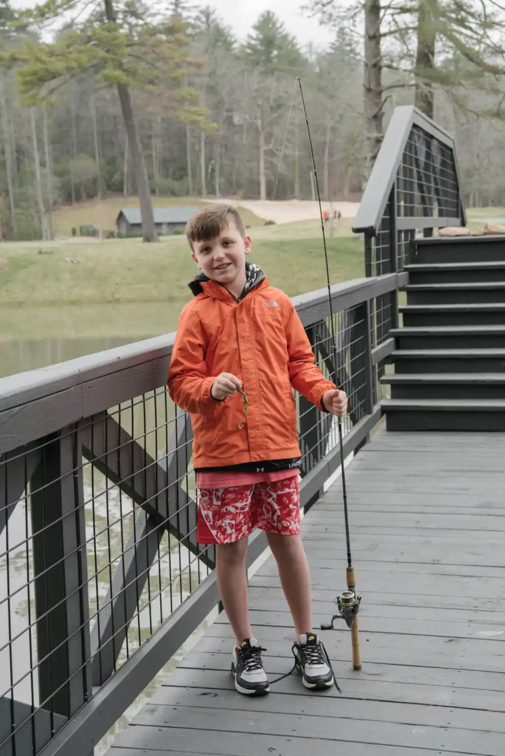 Boy holding a fishing rod while smiling