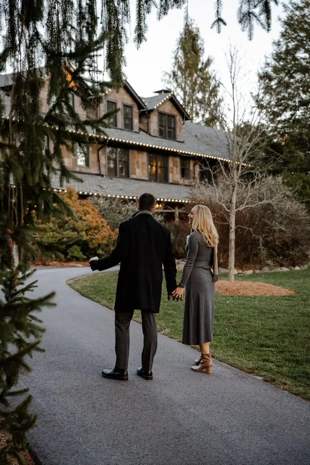A couple holding hands while walking towards High Hampton's Inn