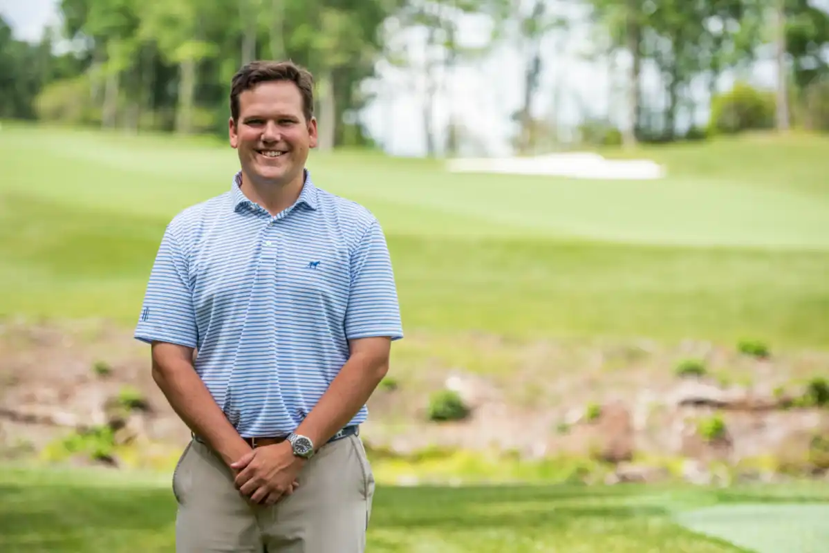 Man smiling with golf course in background