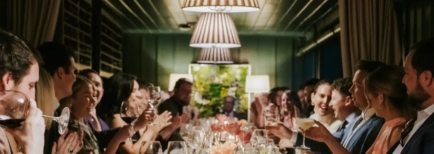 Wedding guests toasting at a dining table in Wine Cellar