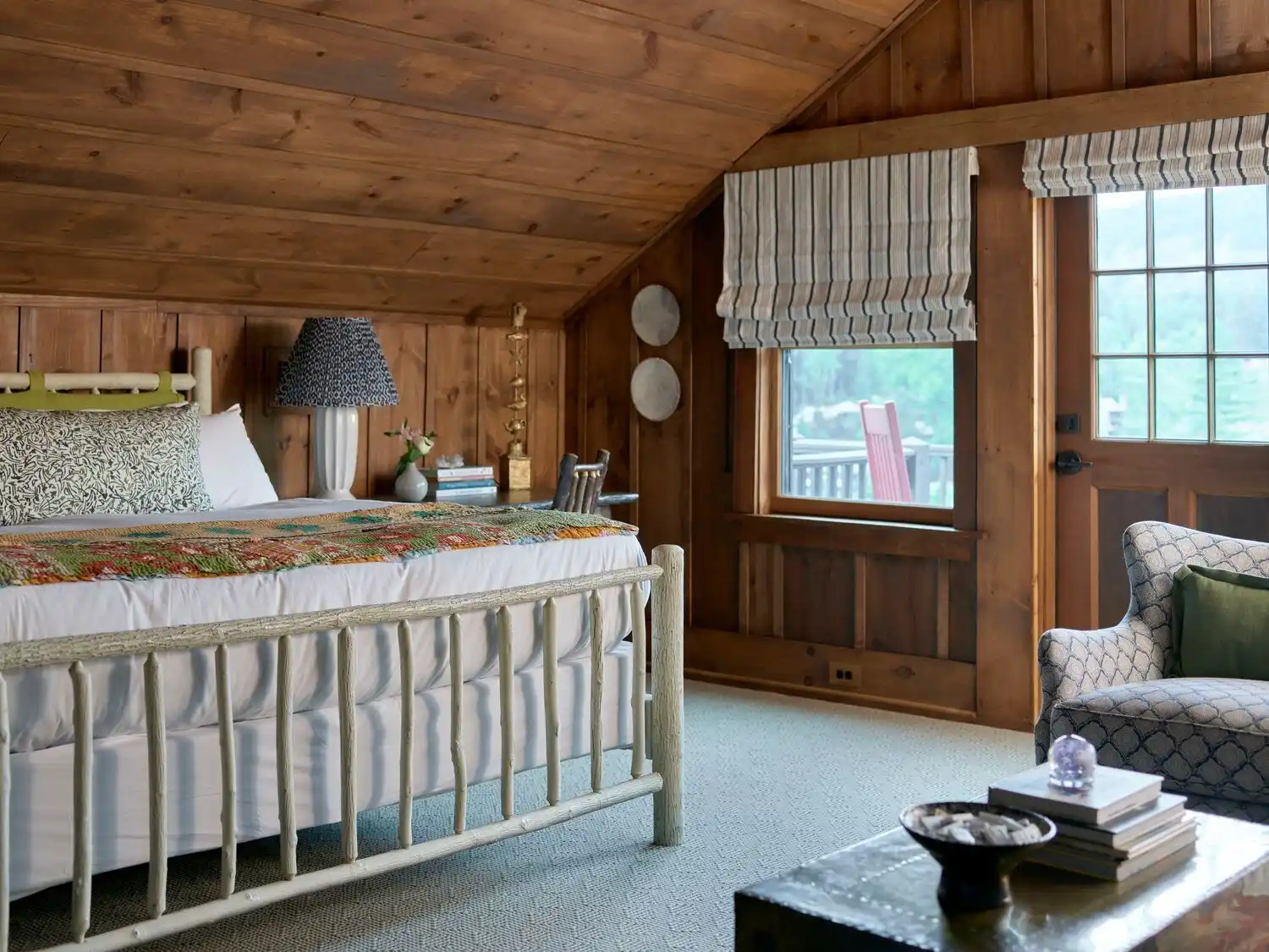 A king bed in a wood paneled bedroom