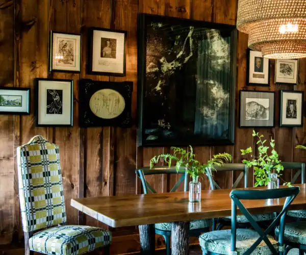 A gallery wall sits behind a dining table at Thorpe Cottage