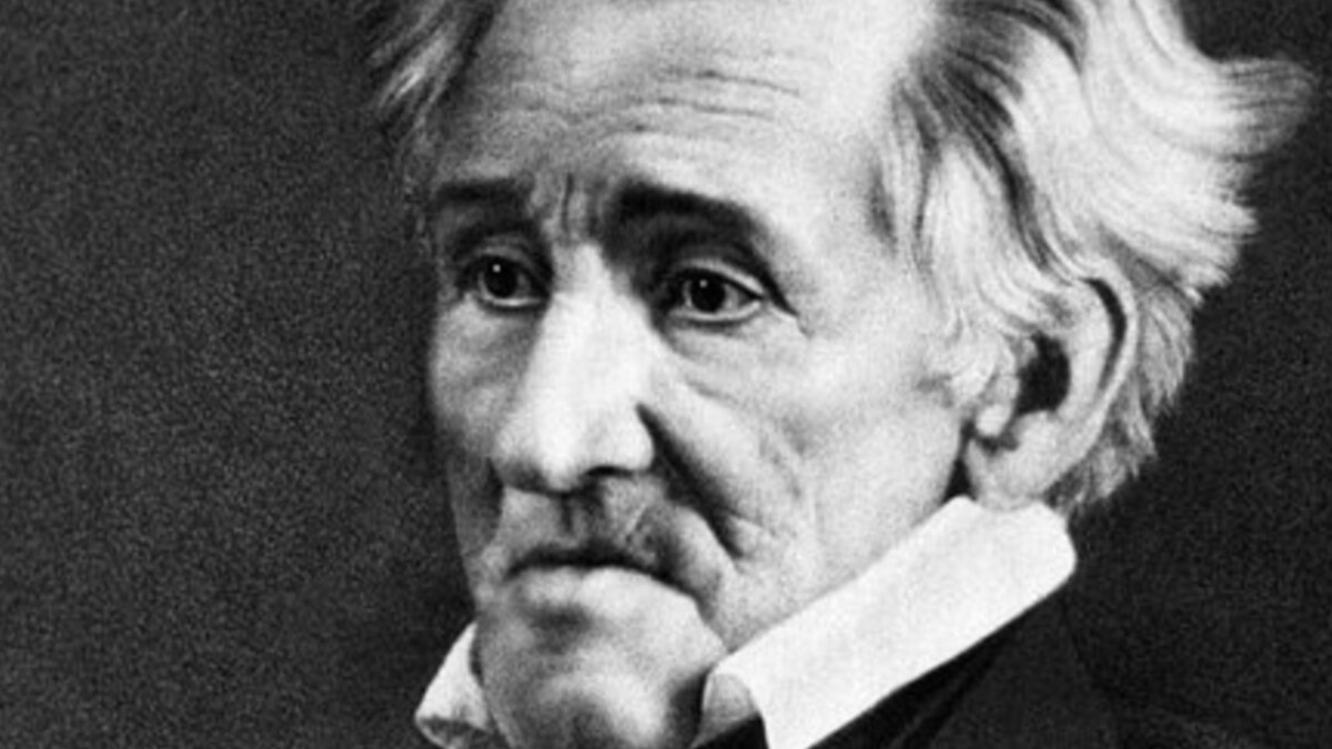 President Andrew Jackson standing defiant as senators debate around him.