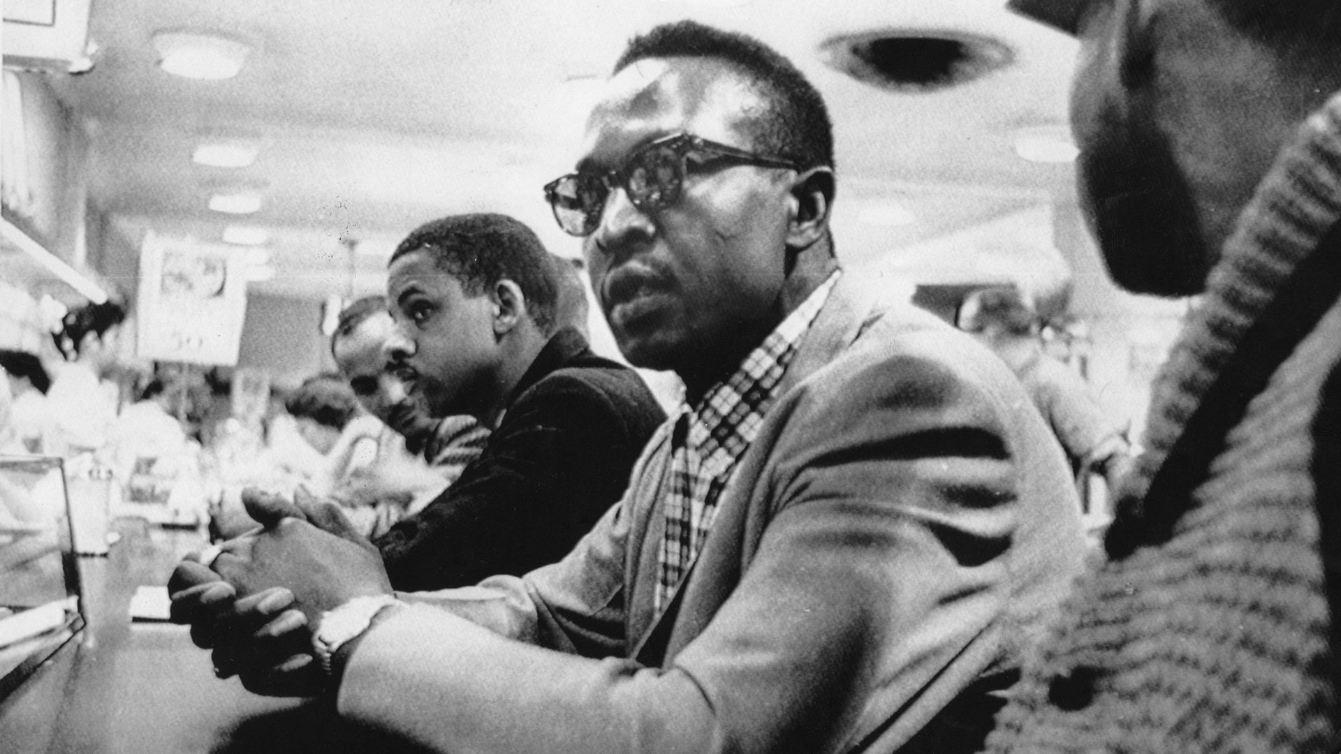 Four Black college students sitting at a Woolworth's lunch counter in Greensboro, North Carolina, refusing to move despite being denied service.