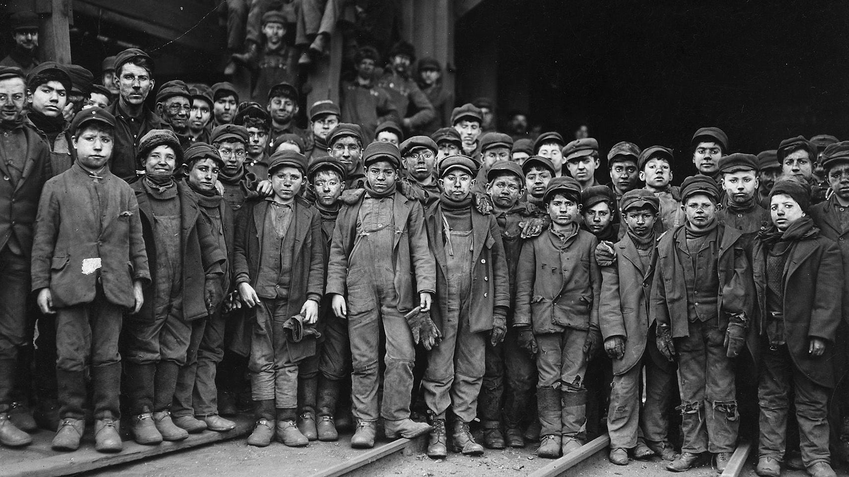 A historical photo of child laborers in a 19th-century textile mill, reflecting the harsh working conditions that led to labor reform.