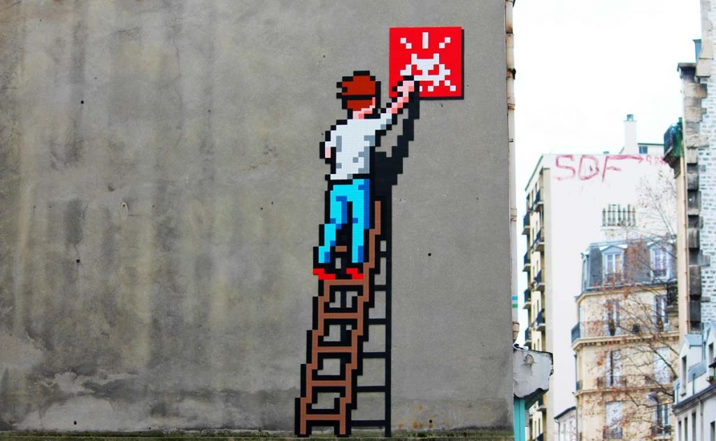 Invader mosaic on a Parisian street corner featuring a classic Space Invader design.