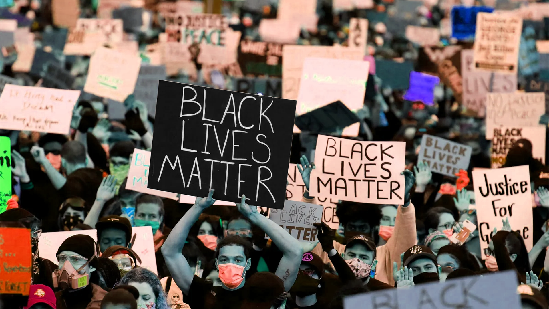 A crowd of protestors holding signs reading 'Black Lives Matter' during a demonstration.