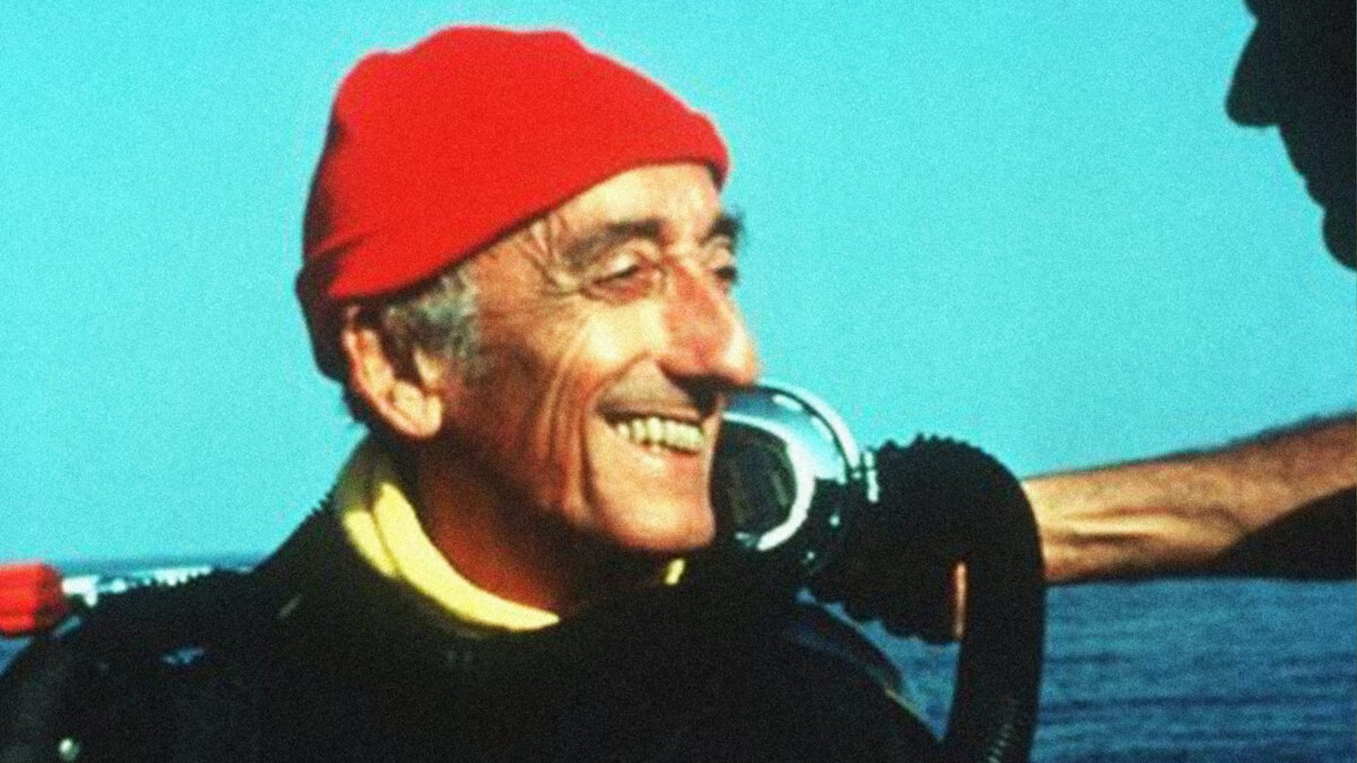 Jacques Cousteau wearing his iconic red cap aboard a ship