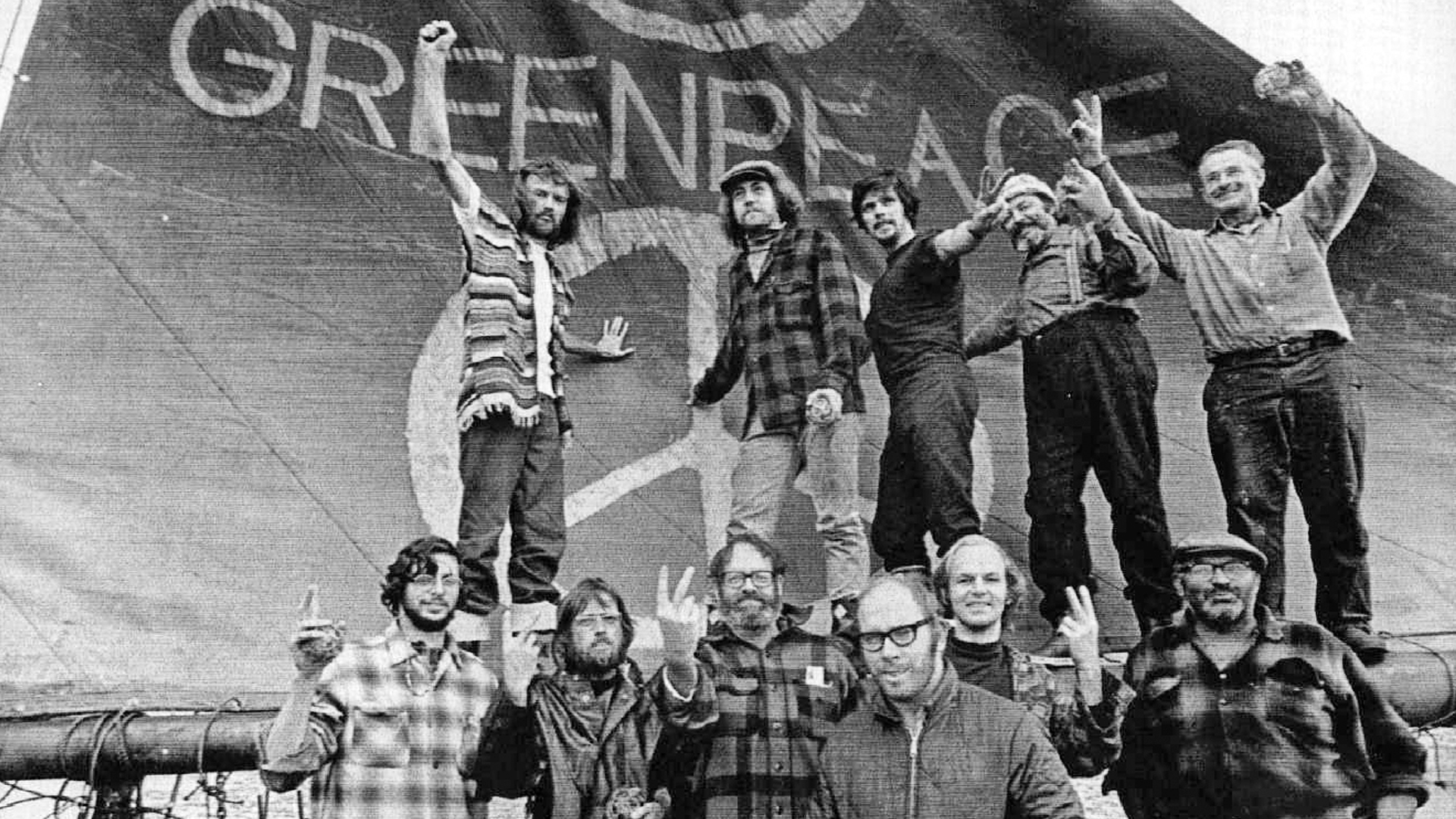 The fishing boat renamed Greenpeace setting sail from Vancouver with activists on deck holding banners.