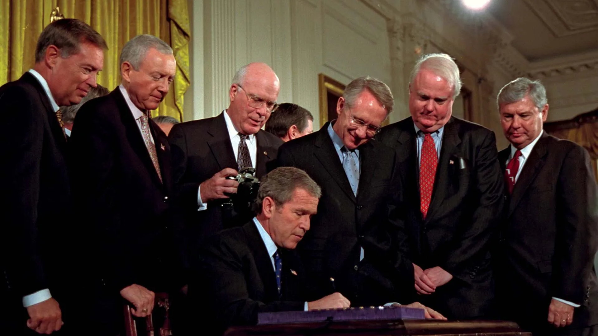 President George W. Bush signs the USA Patriot Act into law, surrounded by members of Congress in 2001.