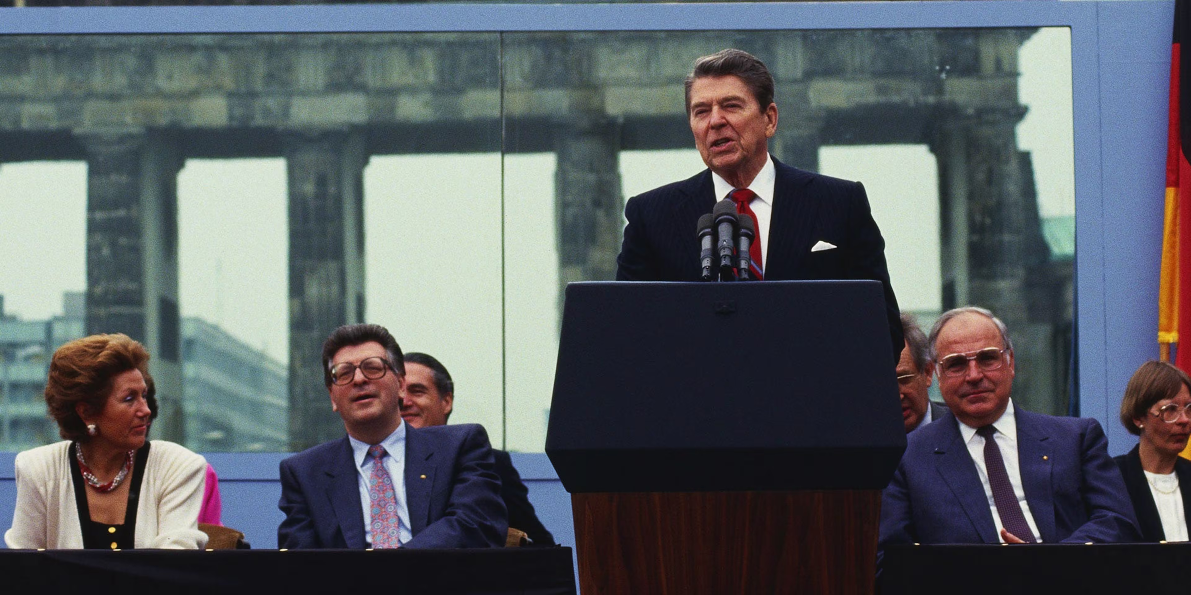 President Ronald Reagan delivering his speech at the Berlin Wall, with the Brandenburg Gate behind him.