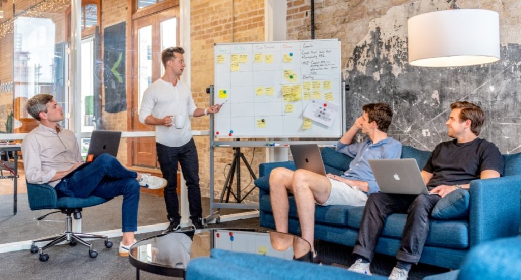 Entrepreneur presenting branded domains to team with whiteboard